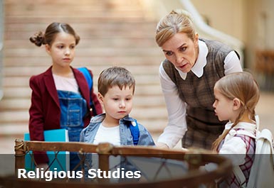A teacher bends down to listen to a child speaking as they look at a religious object in a museum