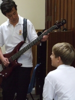 students peer teaching guitar