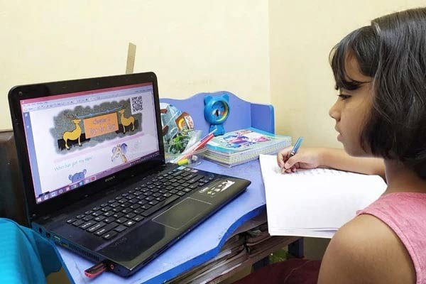 A child in India working at a laptop computer