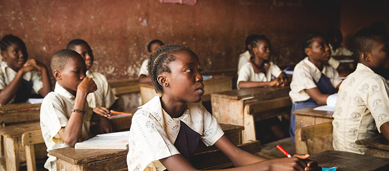 African girls sit at desks in a school classroom