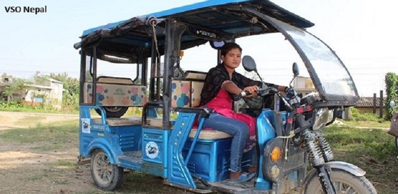 Adolescent girl drives a tuk tuk in Nepal