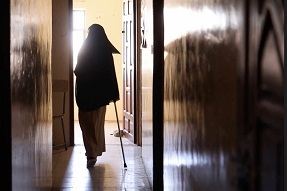 Silhouette of muslim girl walking into her classroom with a walking stick