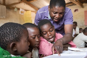 Teacher helps young children in a classroom