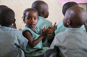 Young girl clapping in classroom, Sierra Leone