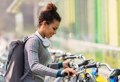 Smiling student parks a bike