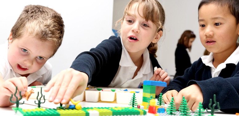 Three children use lego to create stories