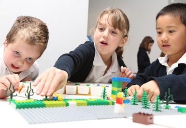three children use lego to create stories