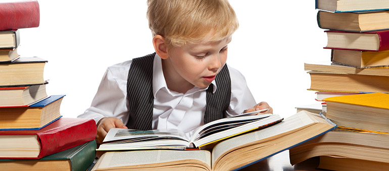 boy looking through a big pile of books