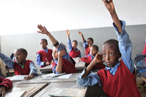 Children putting their hands up in class in Ethiopia