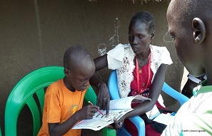 A teacher helps a student with their studies Uganda