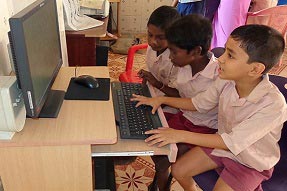 Three students on the computer in primary school in Tamil Nadu, India