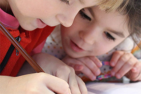 Two primary school children writing together