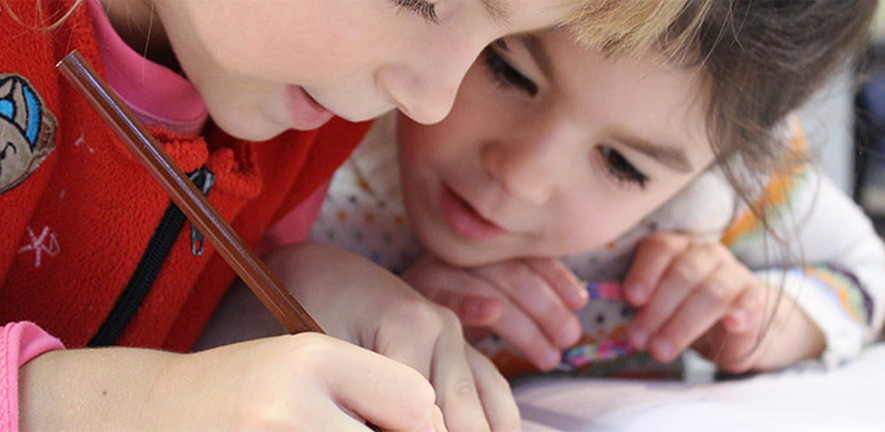 Two primary school children writing together