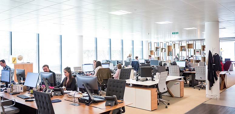 An open office with people sat at desks