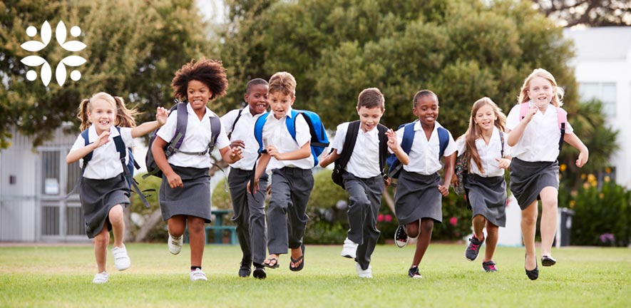 Happy school children run towards the camera