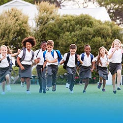 Happy school children run towards the camera