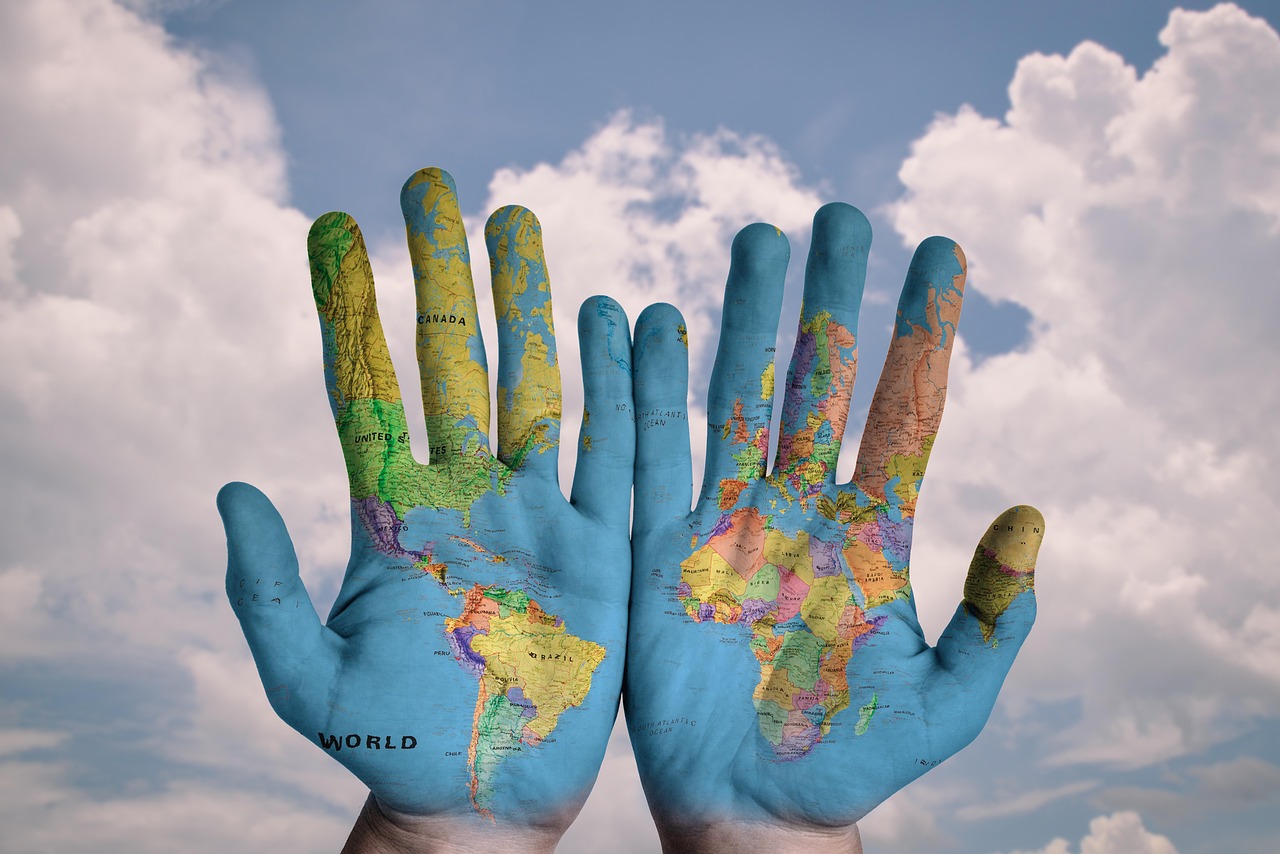 Image showing two hands with the world map found across their palms and centering the African, South and Central American continents.